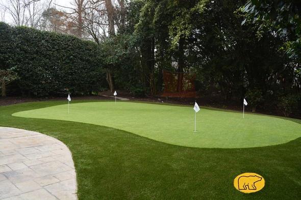 Flagstaff Synthetic grass golf green with 4 holes and flags in a landscaped backyard