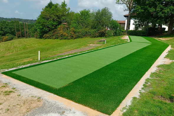 Flagstaff Outdoor tee line consisting of one continuous green synthetic grass strip surrounded by trees